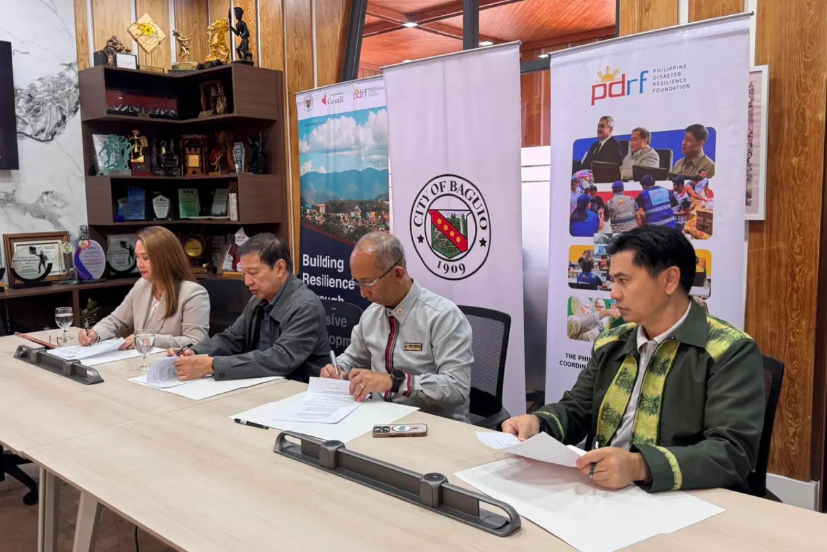 Officials from PDRF and the Baguio City government signing the Memorandum of Agreement at a table flanked by City of Baguio and PDRF banners.